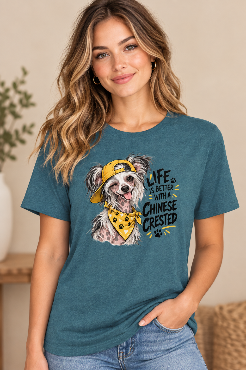 Woman in blue shirt with cartoon Chinese Crested dog design, wearing yellow cap.