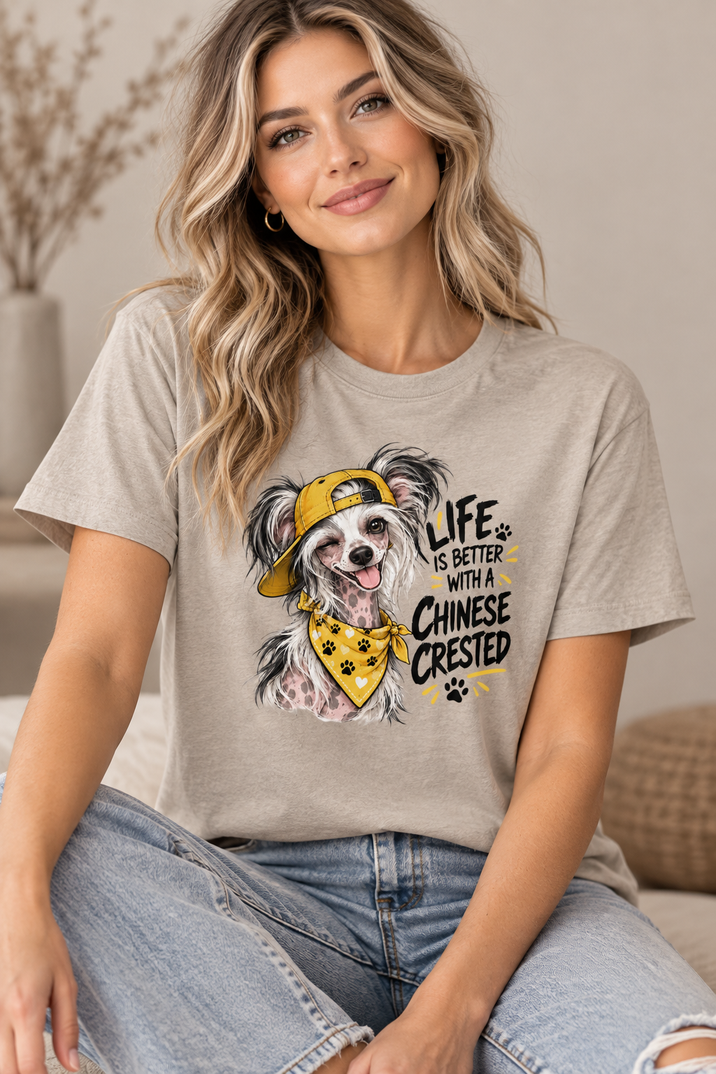 Woman in a beige t-shirt with a cartoon dog wearing a yellow cap and bandana. Text reads “Life is better with a Chinese Crested.”