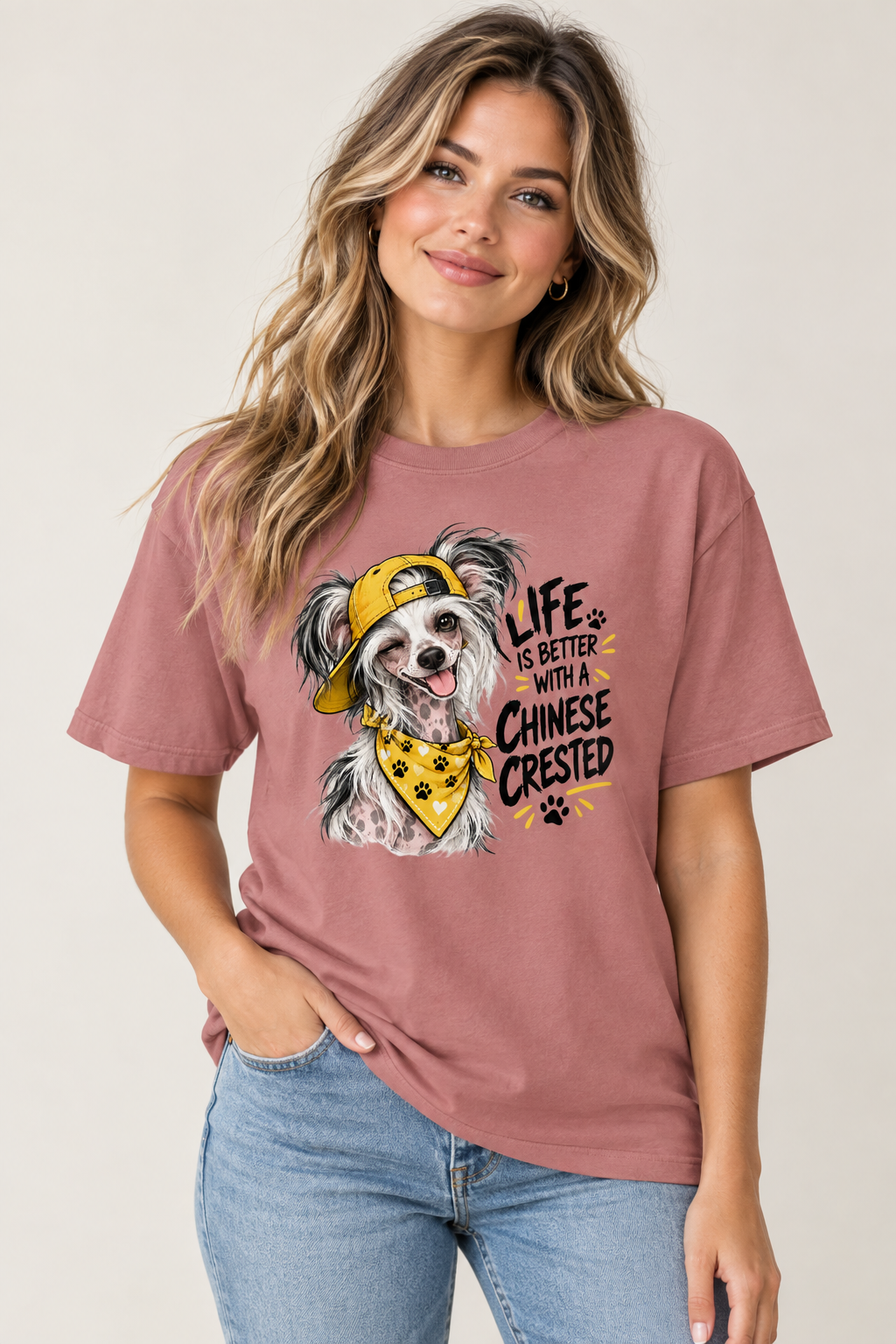 Woman in a pink t-shirt with a dog graphic and text, wearing blue jeans, smiling.