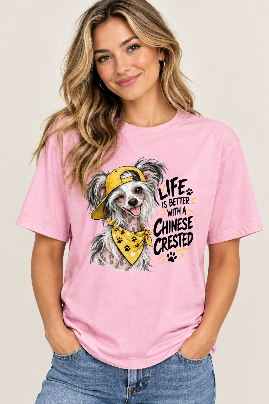 Woman in a pink shirt with a dog graphic and text, wearing jeans, hands in pockets.