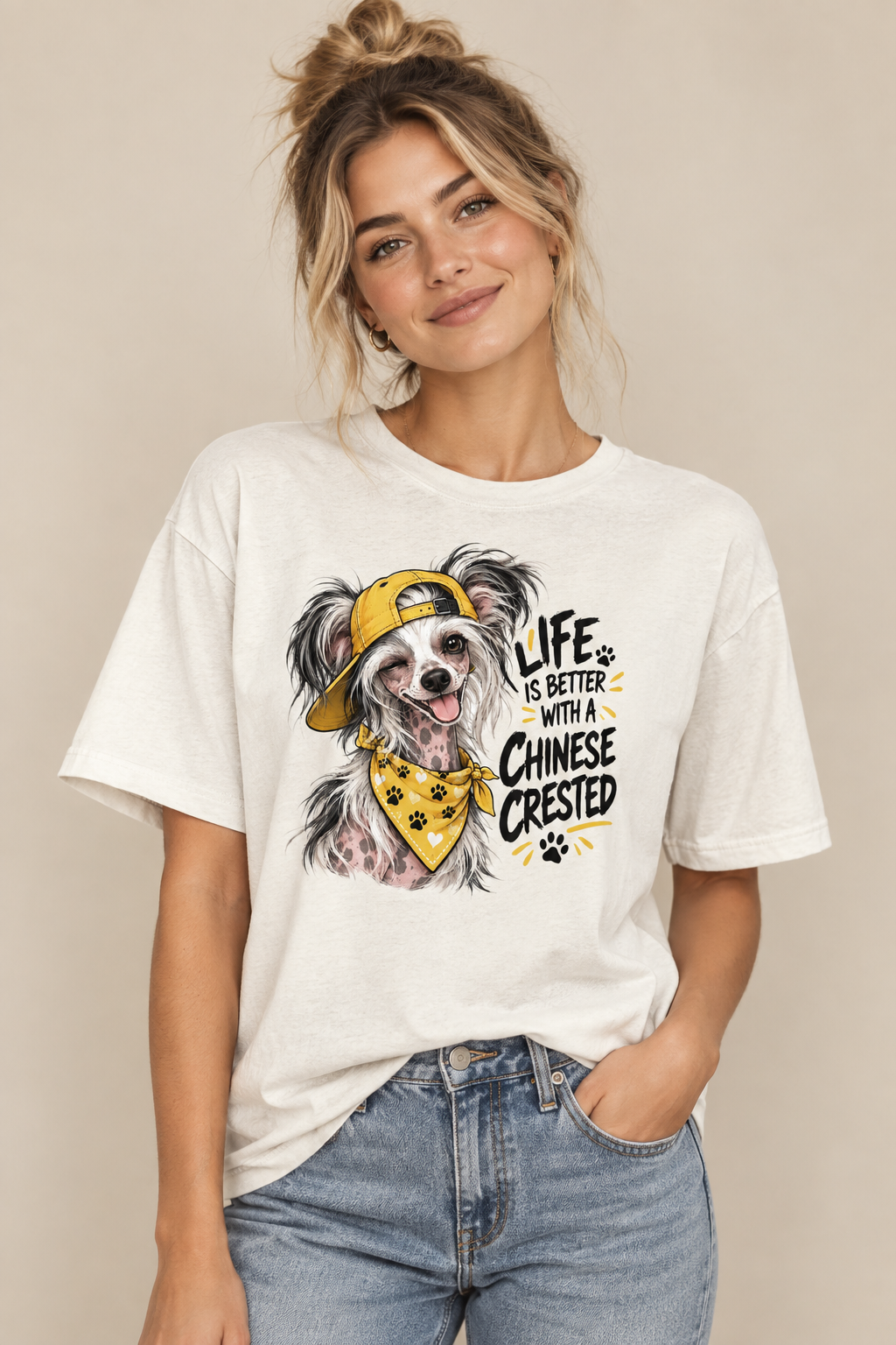 Smiling woman in a white T-shirt with a colorful dog illustration and text, wearing blue jeans.